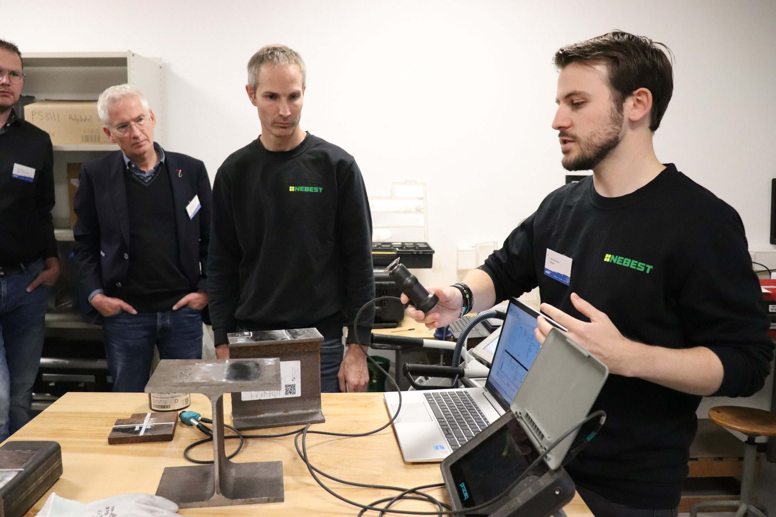 deelnemers krijgen uitleg over staalonderzoek tijdens een rondleiding door het nebest laboratorium